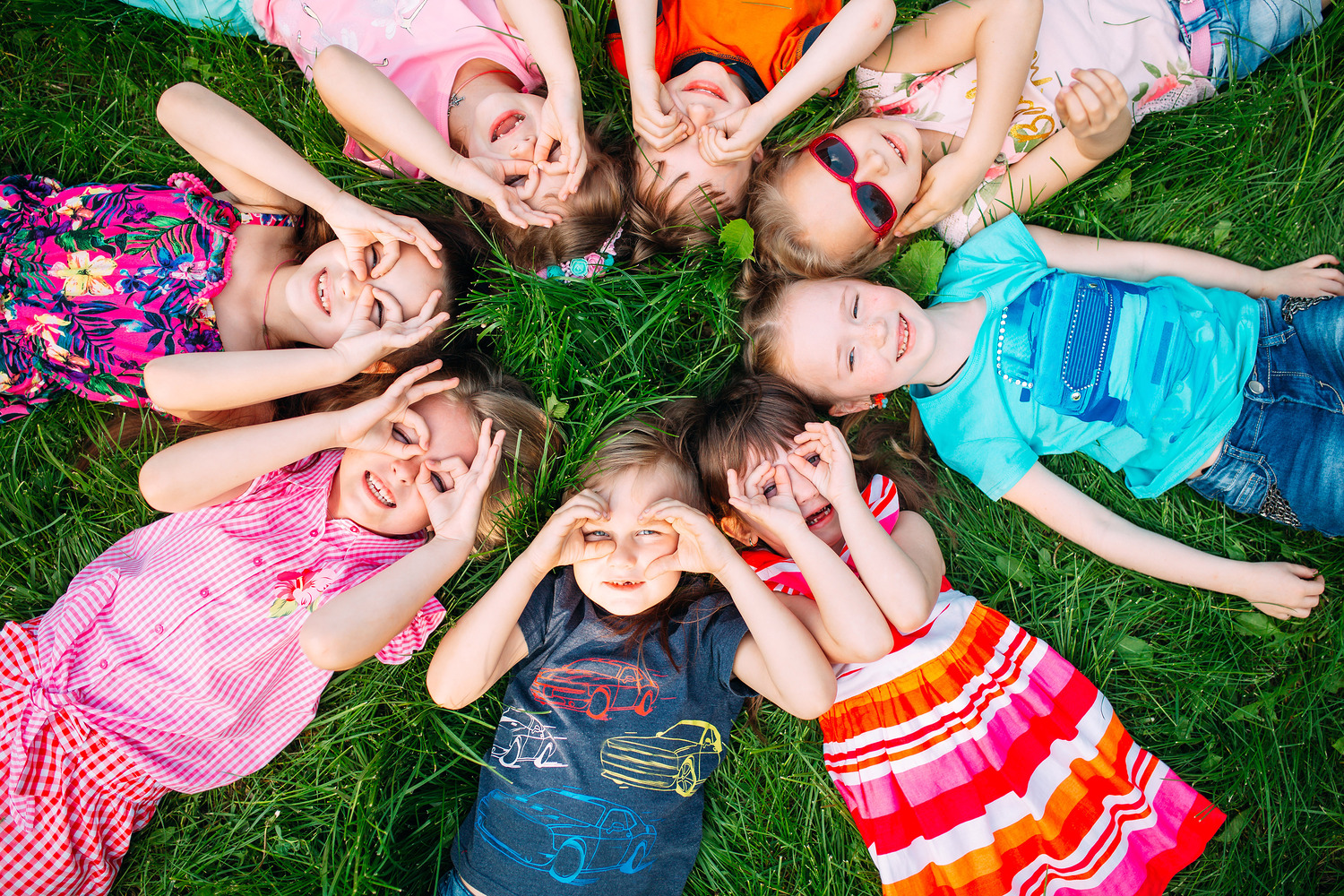 A group of children lying on the green grass in the Park. The in / David Tadevosian photography, davit85 - stock.adobe.com A group of children lying on the green grass in the Park. The interaction of the children